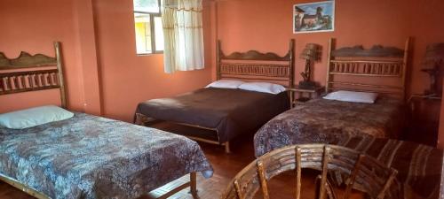 科帕卡巴纳La Leyenda的一间卧室配有两张床和椅子