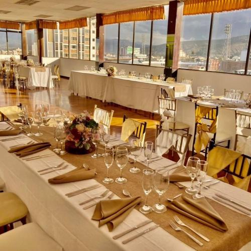 里奥班巴Hotel El Cisne Internacional的用餐室配有白色桌椅和酒杯