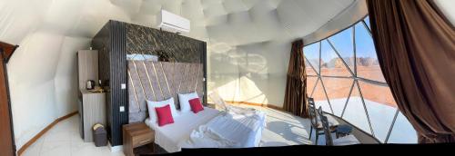 瓦迪拉姆Desert heart camp的一间卧室设有一张大床和大窗户