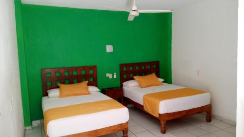 巴拉德纳维达Casa Mexicana Barra de Navidad的绿墙客房的两张床