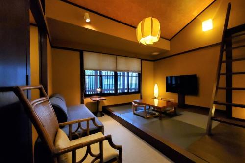宫岛Itsukushimahigashimonzen Kikugawa的客厅配有椅子和电视