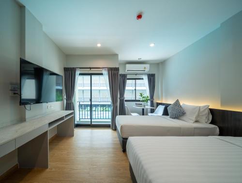 曼谷College Haus Rangnam的酒店客房设有两张床和一台平面电视。