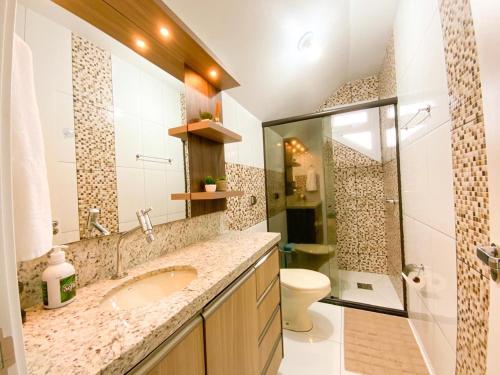 格拉玛多Aconchego do Valle的一间带水槽、淋浴和卫生间的浴室