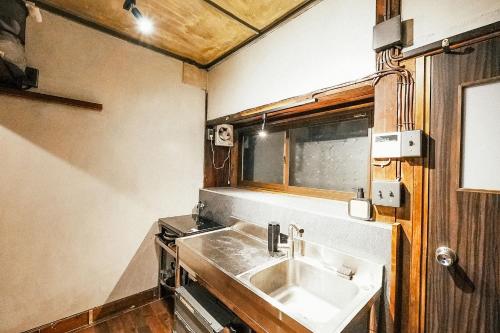 松本松本市の一棟貸し切りできる古民家的厨房设有水槽和窗户。