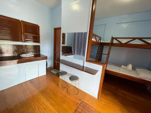 MahinogCamiguin Blue Lagoon Cottages的一间设有两张双层床和两张凳子的房间