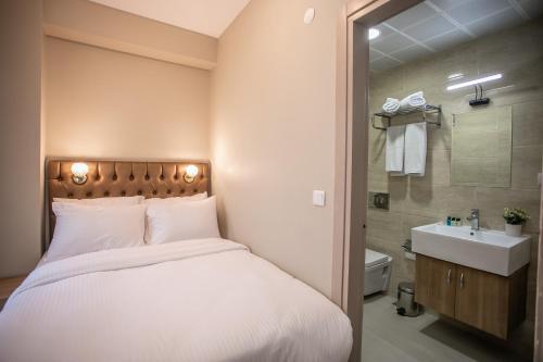 伊斯坦布尔Beyzas Boutique Hotels Suites的一间卧室配有一张床,浴室设有水槽