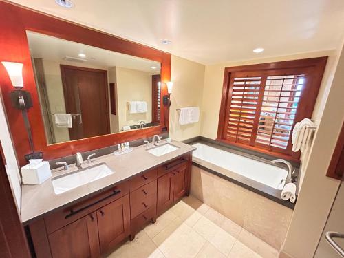 卡波雷Ko Olina Beach Villas O1002 - 3BR Luxury Condo with Stunning Ocean View & 2 Free Parking的浴室设有2个水槽、浴缸和镜子。