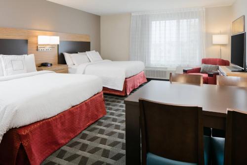 堪萨斯城TownePlace Suites by Marriott Kansas City Airport的酒店客房配有两张床和一张书桌
