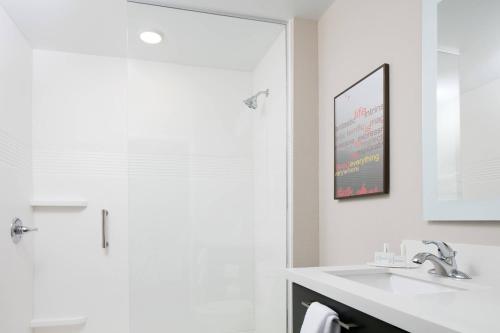 堪萨斯城TownePlace Suites by Marriott Kansas City Airport的白色的浴室设有水槽和淋浴。
