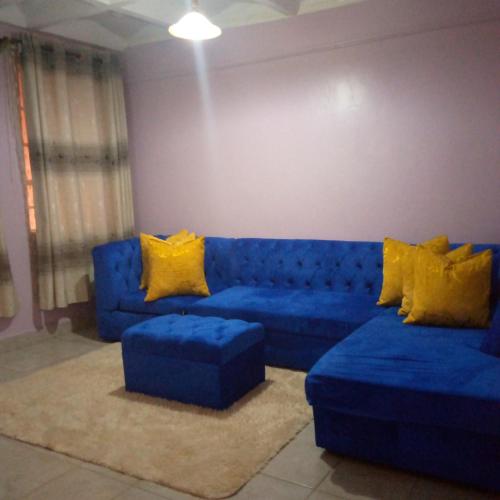 ThikaVerona Apartments的客厅配有蓝色的沙发和黄色的枕头。