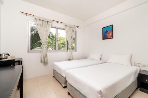 皮皮岛PP Charlie Beach Resort- SHA Plus的白色客房的两张床,设有窗户