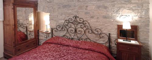 阿尼奥内伊尔巴格利沃公寓的一间卧室设有红色的床和石墙