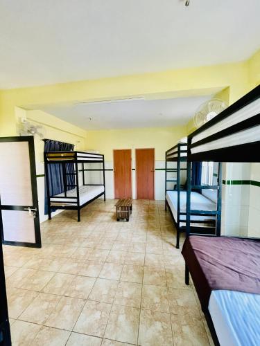 PanamaramLiba rooms panamaram的客房设有三张双层床,铺有瓷砖地板。