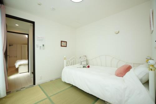 东京Ikebukuro house with 3BR Shinjuku 5min的卧室配有白色的床和镜子