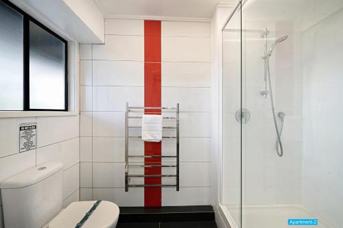 奥克兰玫瑰之家公寓的一间带卫生间的浴室,墙上有一条红色条纹