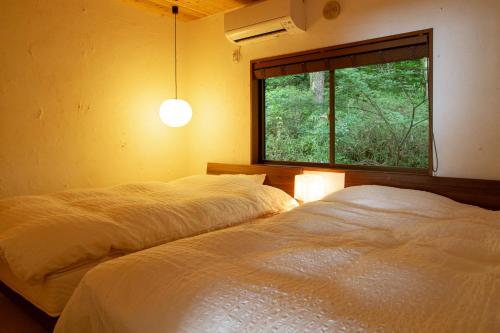 日出町kamenos Luxury Resort With Beautiful Scenery Hiji的卧室设有两张床,带窗户