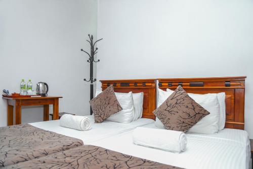 康提Kandy Tower Inn的一间卧室配有一张带白色和棕色枕头的大床