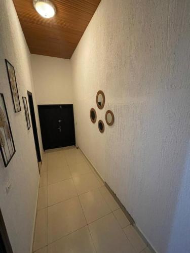 OuidahLOUKPEMI BUSINESS IL SARL的一条铺有白色地板和黑色门的走廊