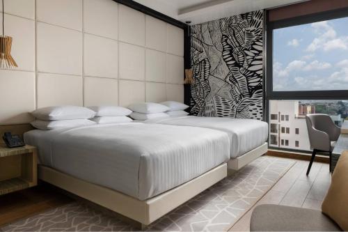 拉各斯Lagos Marriott Hotel Ikeja的卧室设有一张白色大床和一扇窗户。