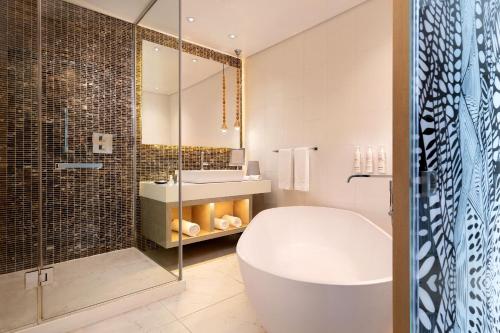 拉各斯Lagos Marriott Hotel Ikeja的带浴缸、水槽和淋浴的浴室