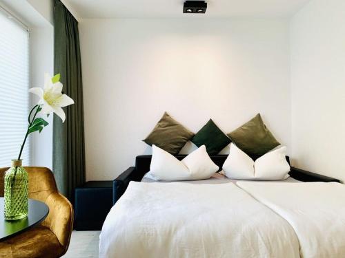 万根沃格Sea air Modern retreat的卧室配有一张白色的床,桌子上摆放着花瓶
