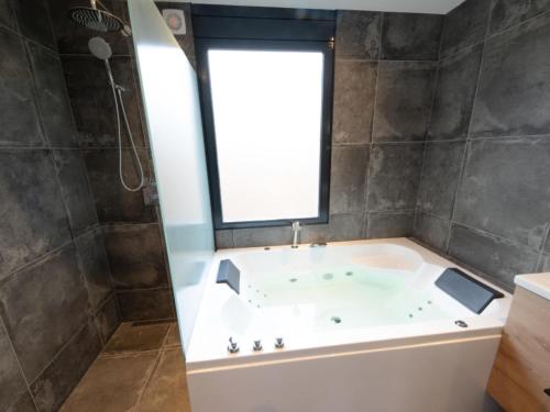 ZevenhuizenWellness Bungalow with whirlpool and sauna的带浴缸的浴室和窗户