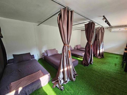 考索Nahm Khao Sok的一间设有三张床的客房,铺有绿色地毯