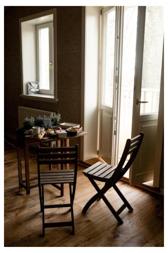 恩古雷Pērlerada room的用餐室配有桌子、两把椅子、一张桌子和一张桌子
