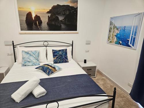 卡普里La Bomboniera的一间卧室配有带白色床单和蓝色枕头的床。