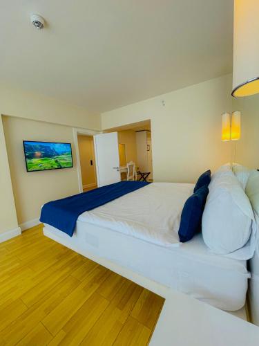 巴统Luxury Batumi Hotel的卧室配有带蓝色枕头的大型白色床