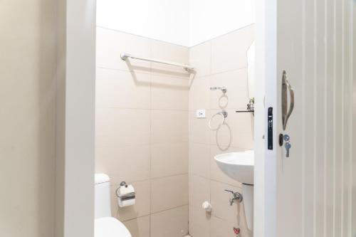 大雅台风之公寓4号的白色的浴室设有卫生间和水槽。