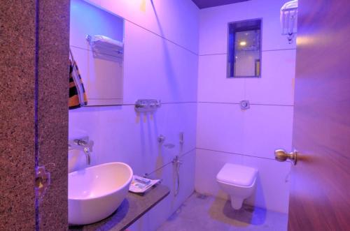 JalālpurHare Krishna Hotel的白色的浴室设有水槽和卫生间。