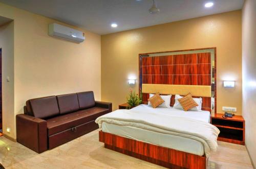 JalālpurHare Krishna Hotel的一间卧室配有一张床和一张皮沙发