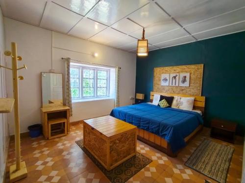科代卡纳尔De Huts Kodaikanal的一间卧室设有一张床和蓝色的墙壁