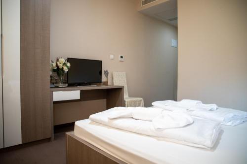 梅特科维奇Hotel Narenta的一间卧室配有一张带白色床单的床和一台电视。