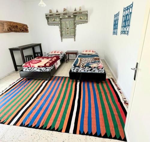 苏塞Anis 2的客房内的两张床,地板上铺有色彩缤纷的地毯。