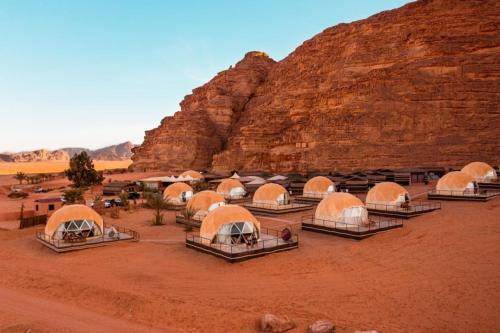 瓦迪拉姆Hasan Zawaideh Camp的悬崖附近的沙漠中一群帐篷