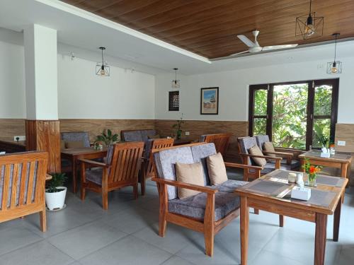 博卡拉山房子旅馆的客厅配有木椅和桌子