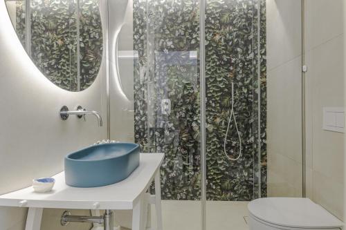 托雷苏达Le Gemelle Boutique Hotel的浴室配有蓝色水槽和淋浴。