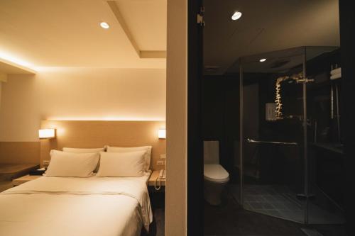 台北二十轮旅店西门町馆的酒店客房带一张床和一个玻璃淋浴间