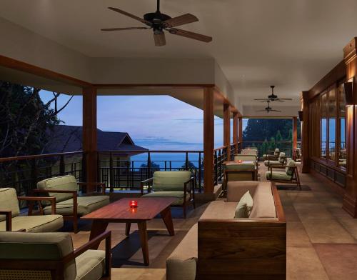 KurseongTaj Chia Kutir Resort & Spa Darjeeling的一个带沙发和桌子的门廊,享有海景