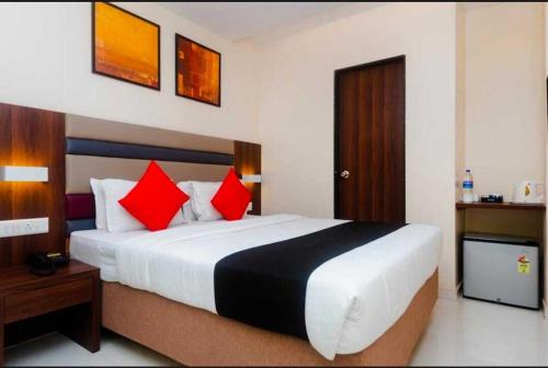 孟买Hotel Regal International - Near Mumbai International Airport Andheri East的一间卧室配有一张带红色枕头的大床