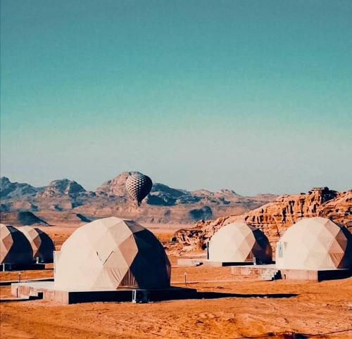 瓦迪拉姆wadi rum camp stars & jeep tour的一群在沙漠中的圆顶,有山