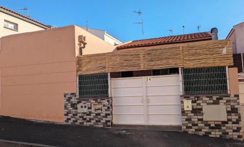 格拉纳迪利亚德亚沃纳HAPPY ROOM的街道上设有两扇车库门的建筑