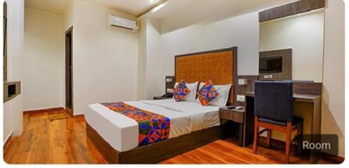 孟买Hotel Royal Palace Kurla的一间卧室配有一张床、一张桌子和一把椅子