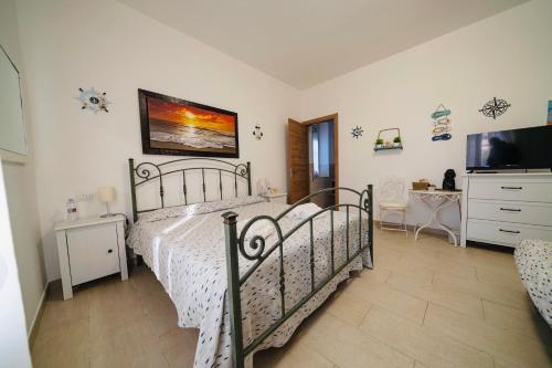波尔图·埃尔科莱Il Poggetto di Porto Ercole的一间卧室配有一张床和一台平面电视