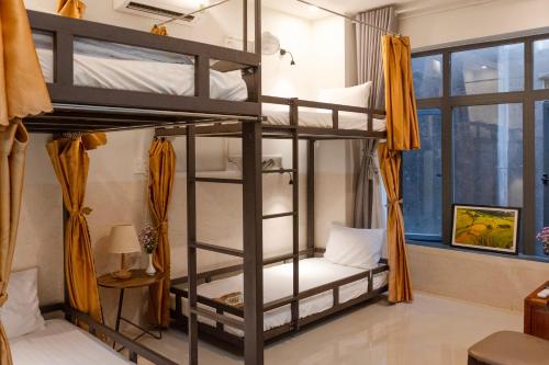 会安Phuoc Dat Riverside Homestay Hoi An的客房设有两张双层床和一扇窗户。