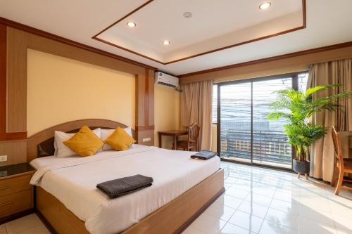 南芭堤雅La Casa South Pattaya Hotel的一间卧室设有一张大床和一个大窗户