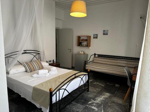 SifnosKIRIKOS ROOMS的一间卧室配有一张床和长凳