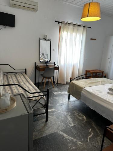SifnosKIRIKOS ROOMS的一间卧室配有两张床和一张带镜子的书桌